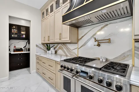 a kitchen with a stove a counter space and a view of living room