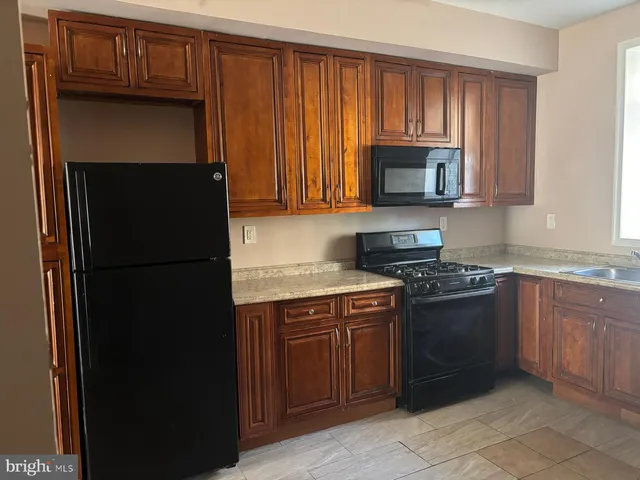 a kitchen with granite countertop stainless steel appliances a stove a sink and a microwave