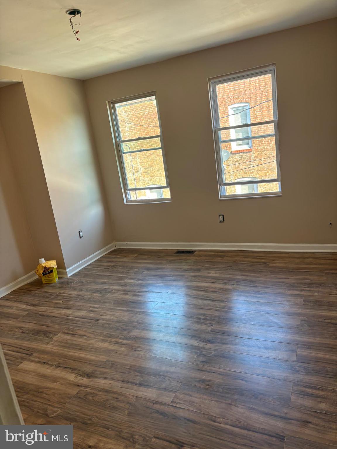 2328 East Madison Street Baltimore, MD 21205 - Photo 4 of 10 an empty room with wooden floor and windows