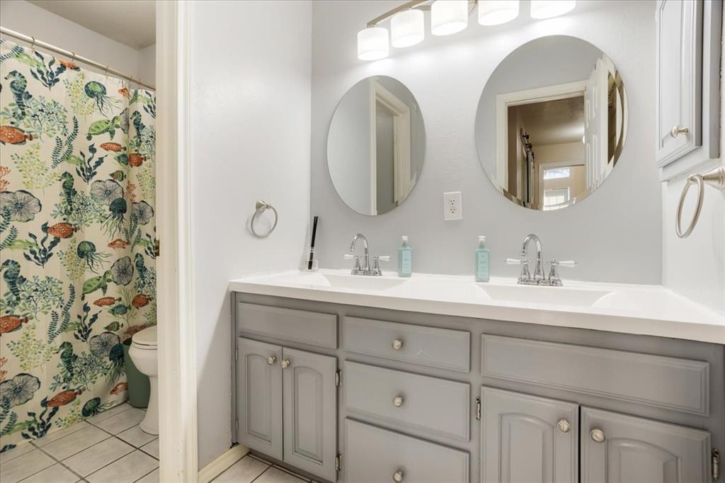 227 North Hopson Street Van Alstyne, TX 75495 - Photo 16 of 38 a bathroom with a double vanity sink and mirror