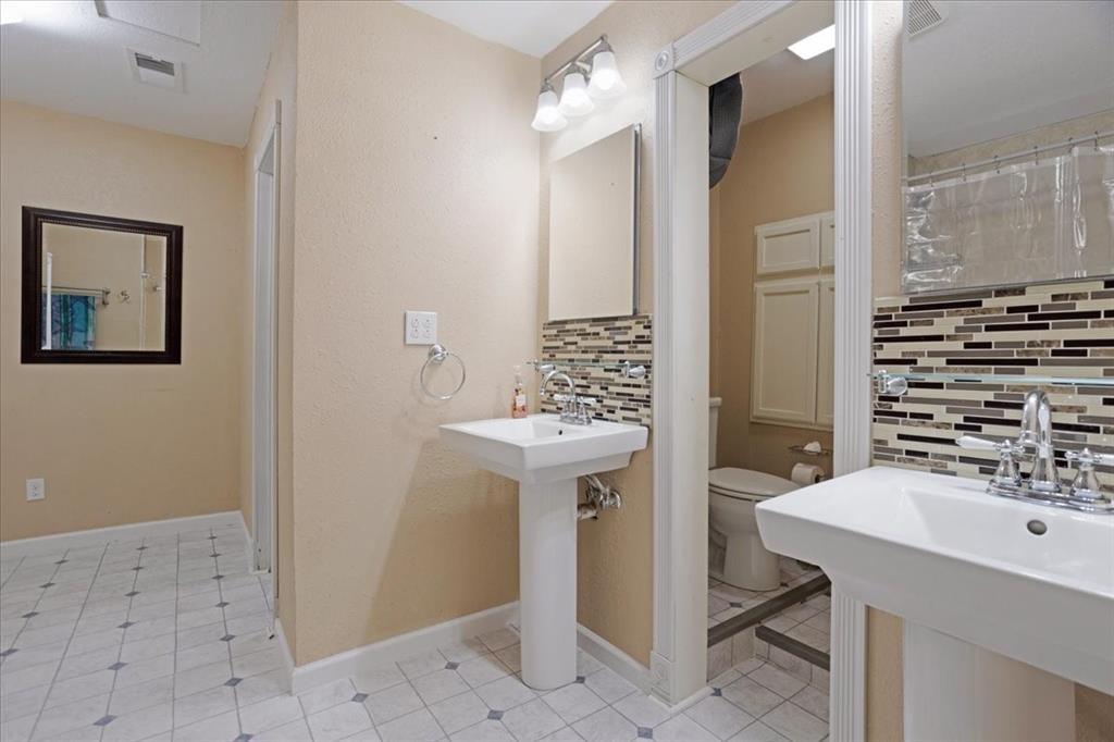 227 North Hopson Street Van Alstyne, TX 75495 - Photo 31 of 38 a bathroom with a sink a mirror and a shower