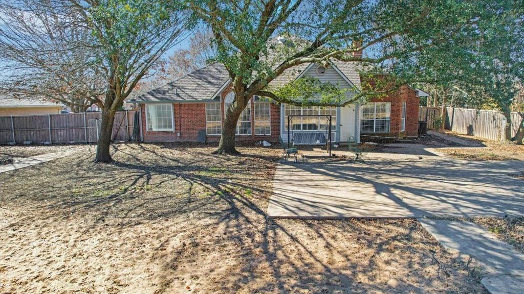 227 North Hopson Street Van Alstyne, TX 75495 - Photo 35 of 38 a tree in front of a brick house with a large tree