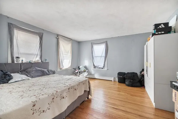 a bedroom with a bed window and a dresser