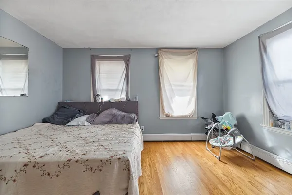 a bedroom with a bed and a dresser next to a window