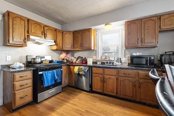 a kitchen with stainless steel appliances granite countertop a stove sink and cabinets