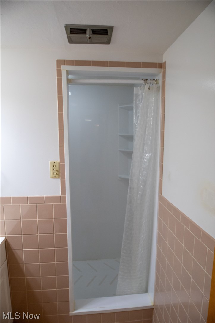 7674 Ragall Parkway Cleveland, OH 44130 - Photo 21 of 32 Bathroom featuring tile walls and a shower with curtain