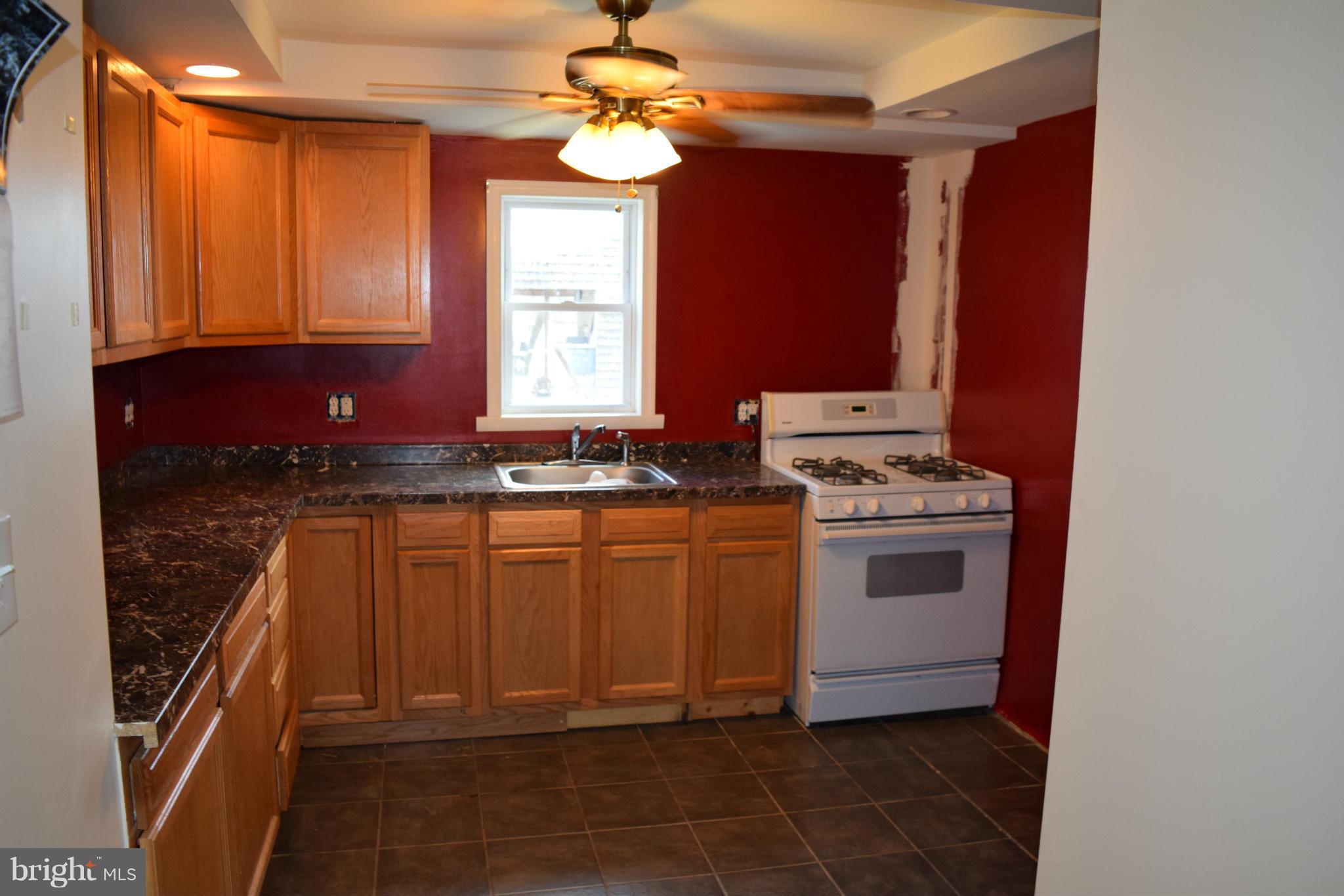 7737 Fairgreen Road Baltimore, MD 21222 - Photo 6 of 28 a kitchen with stainless steel appliances granite countertop a stove a sink and a refrigerator