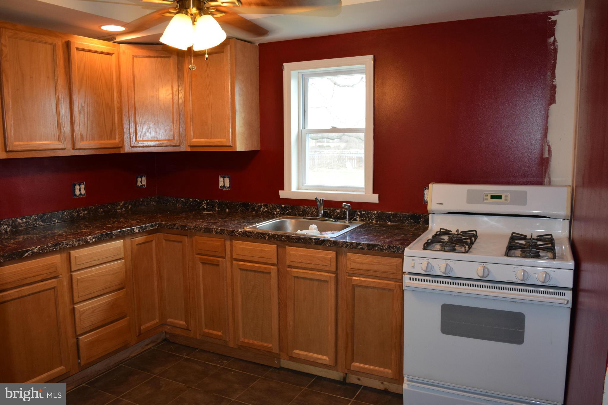 7737 Fairgreen Road Baltimore, MD 21222 - Photo 8 of 28 a kitchen with a sink stove and cabinets