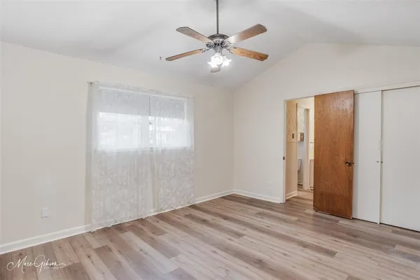a view of a room with wooden floor and a ceiling fan
