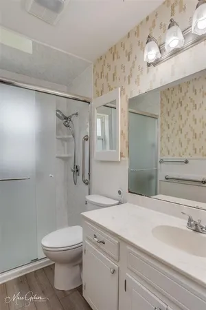 a bathroom with a sink a toilet and shower