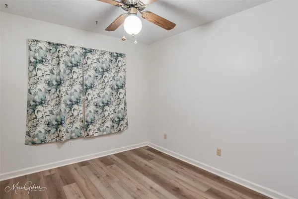 an empty room with a window and a fan
