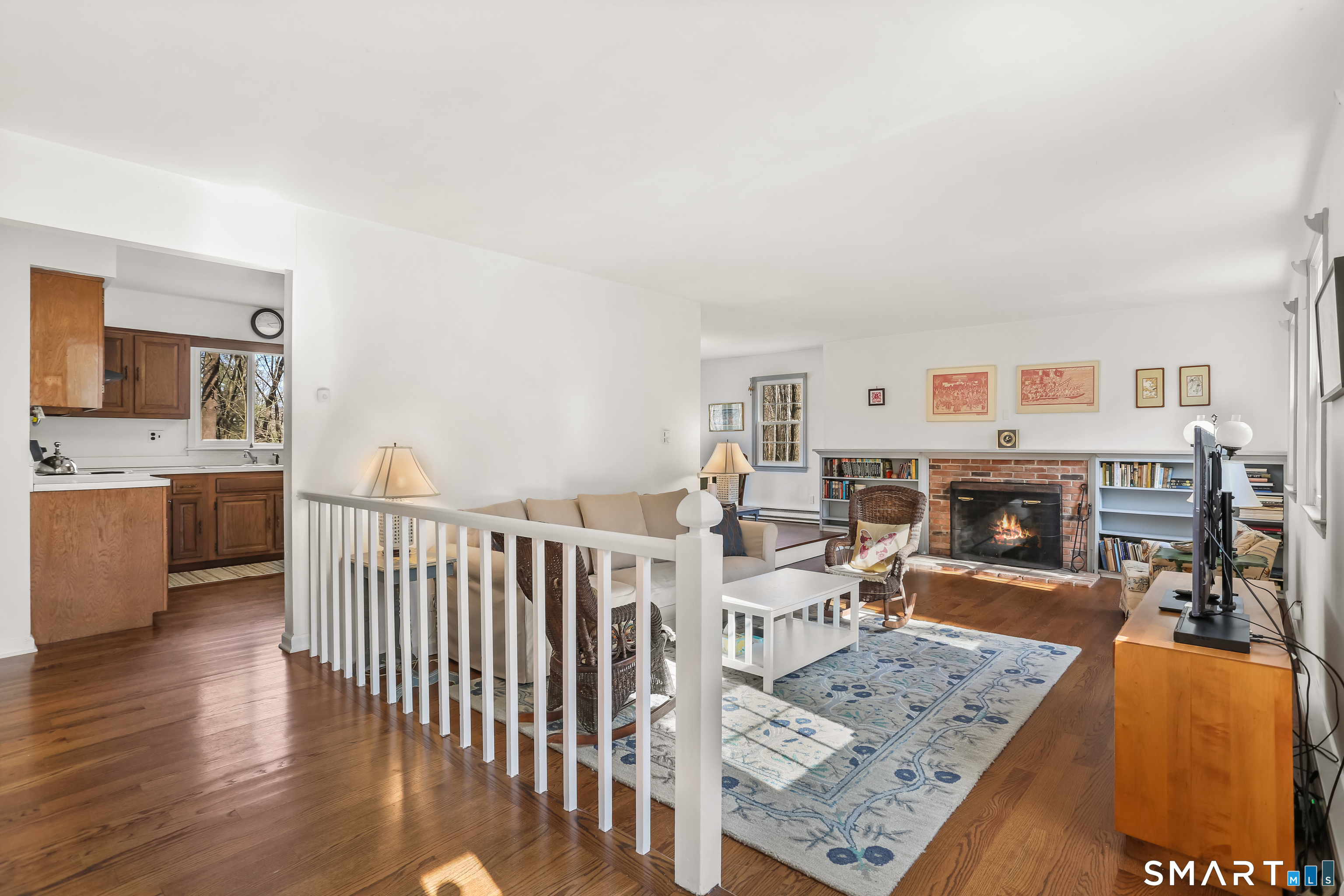 268 Umpawaug Road Redding, CT 06896 - Photo 2 of 30 a living room with furniture a fireplace and a kitchen view