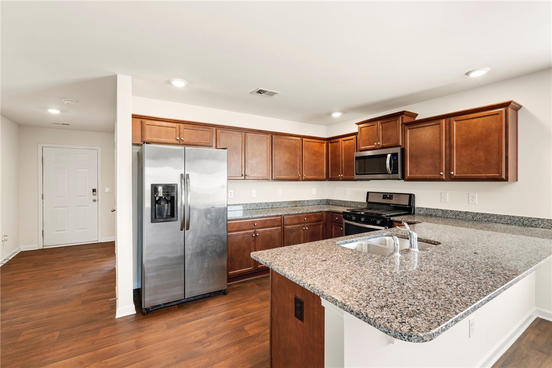 205 Hillendale Way Pelzer, SC 29669 - Photo 10 of 29 This kitchen features rich cabinetry, sleek stainless steel appliances, and durable granite countertops.