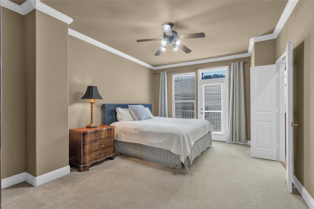 5724 Robbie Road Plano, TX 75024 - Photo 20 of 29 a spacious bedroom with a bed and a chandelier