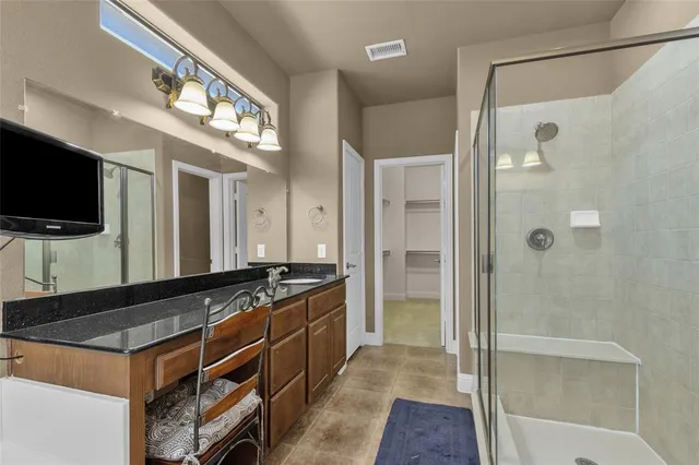 a spacious bathroom with a granite countertop sink a large mirror a shower and a bathtub
