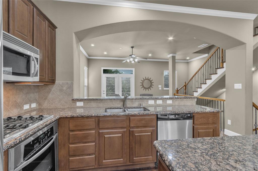 5724 Robbie Road Plano, TX 75024 - Photo 3 of 29 a kitchen with granite countertop a sink and stove