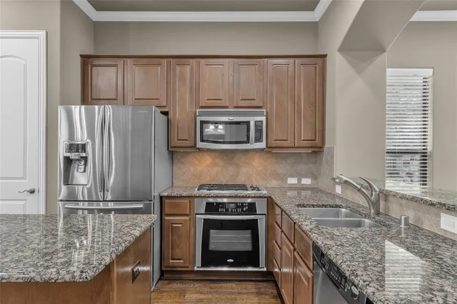 a kitchen with granite countertop a stove and a microwave