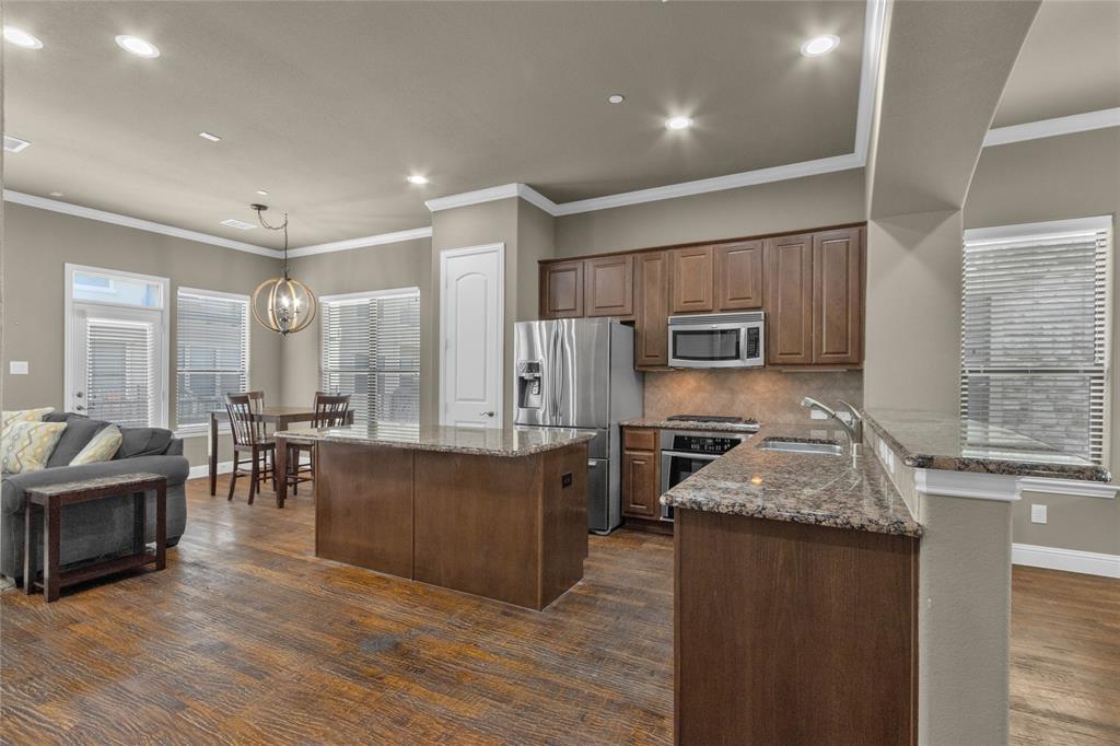 5724 Robbie Road Plano, TX 75024 - Photo 5 of 29 a large kitchen with kitchen island granite countertop a large counter top appliances and cabinets