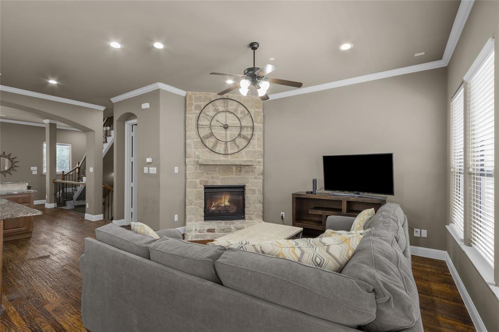 5724 Robbie Road Plano, TX 75024 - Photo 9 of 29 a living room with furniture a fireplace and a flat screen tv