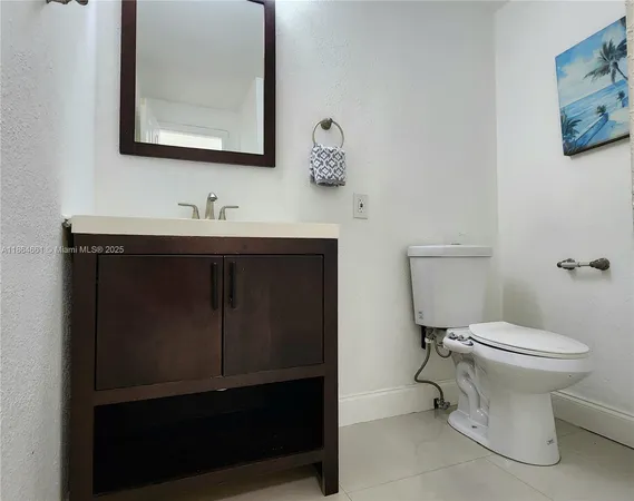 a spacious bedroom with a bed a mirror on the dresser and a window