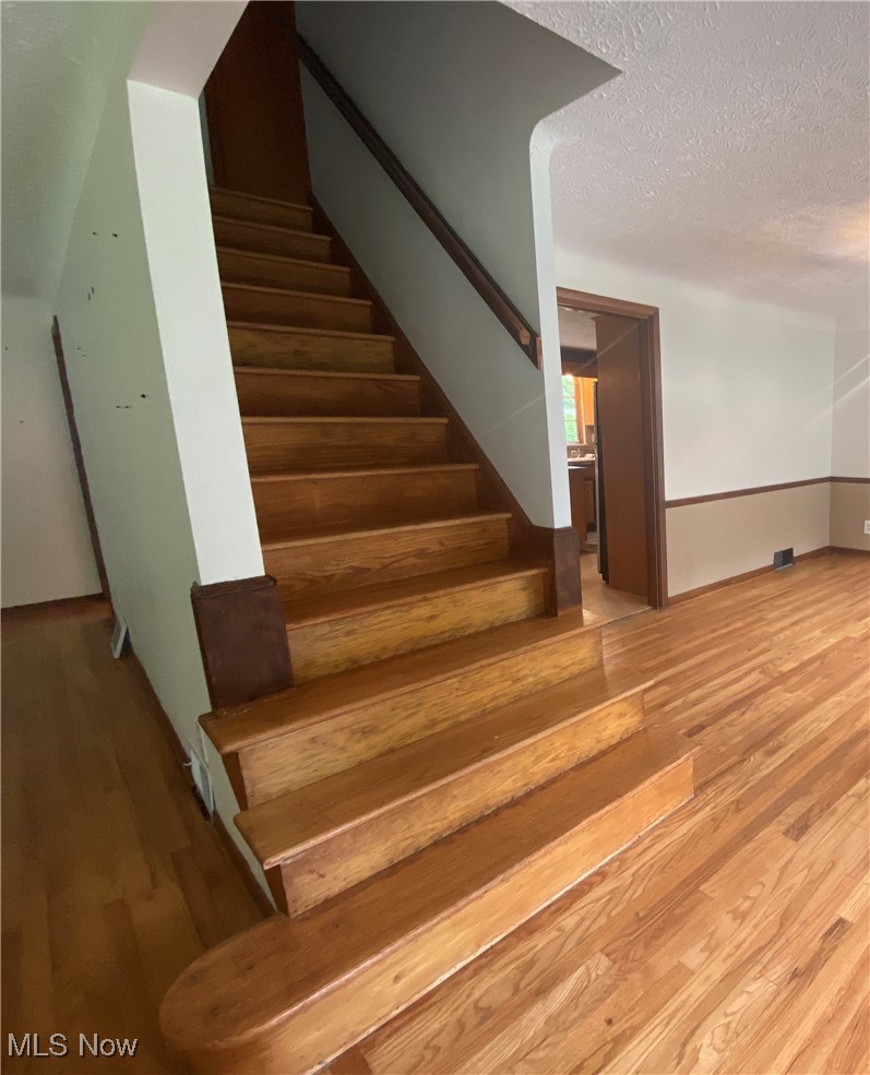3601 Brinkmore Road Cleveland, OH 44121 - Photo 25 of 45 Stairs featuring a textured ceiling and hardwood / wood-style flooring