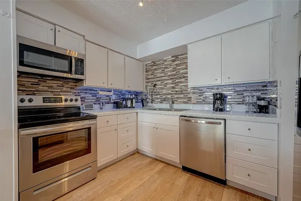 a kitchen with white cabinets stainless steel appliances and sink