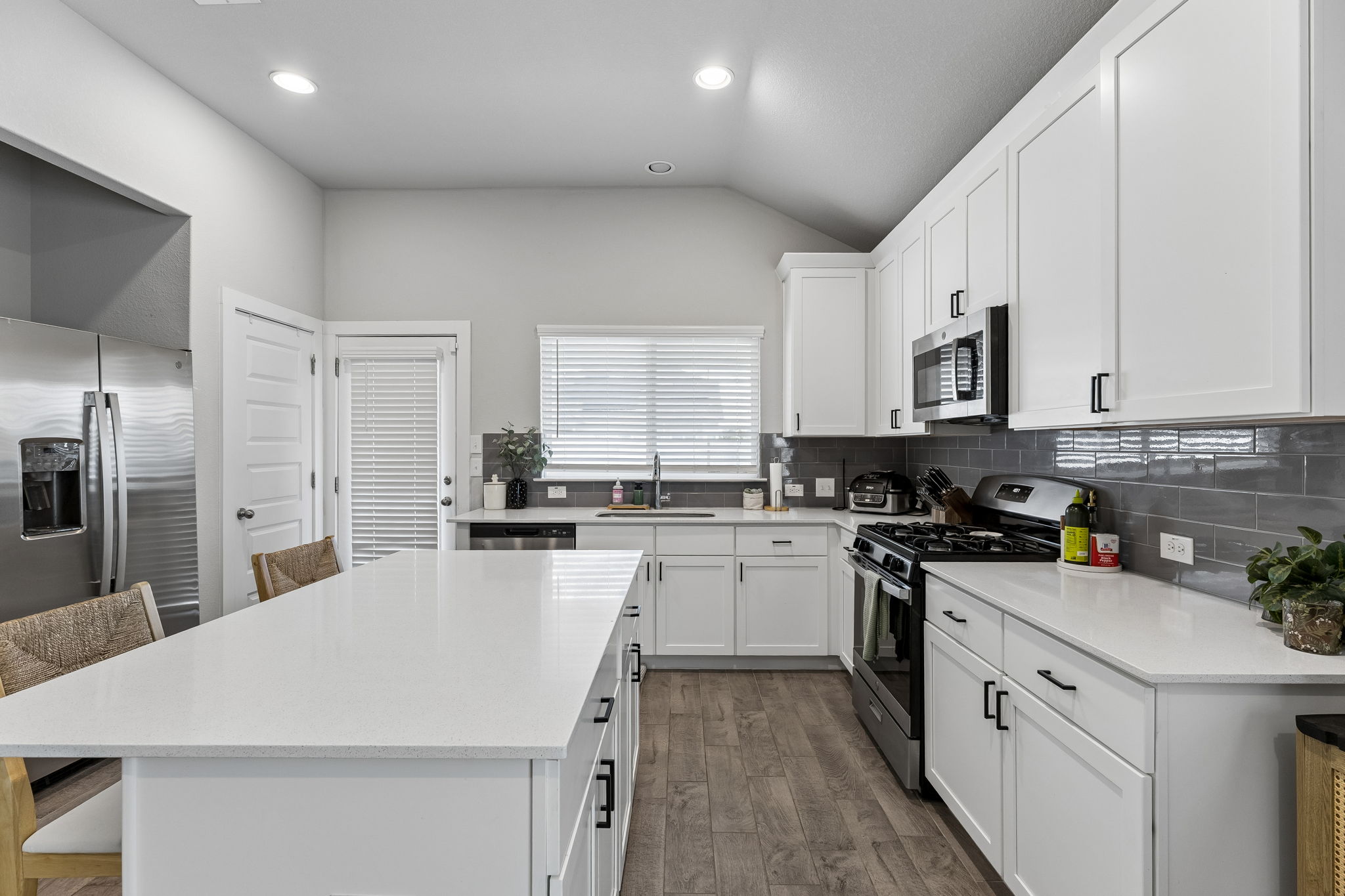 164 Appleberry Lane Elgin, TX 78621 - Photo 7 of 40 Gleaming stone countertops and modern shaker cabinetry frame this highly functional workspace.
