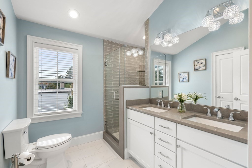 25 Cherry Street, Unit 3 Danvers, MA 01923 - Photo 24 of 27 a bathroom with a sink a toilet a mirror a vanity a window and vanity