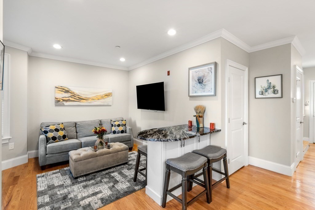 25 Cherry Street, Unit 3 Danvers, MA 01923 - Photo 3 of 27 a living room with furniture and a flat screen tv