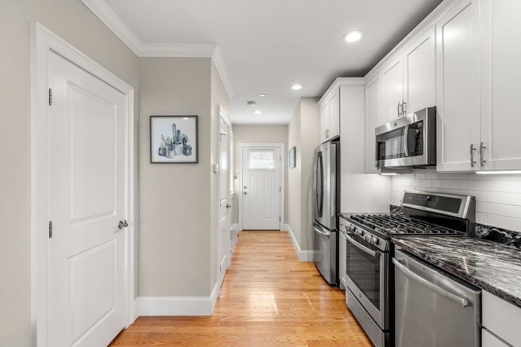 25 Cherry Street, Unit 3 Danvers, MA 01923 - Photo 5 of 27 a kitchen with stainless steel appliances a refrigerator and a stove top oven