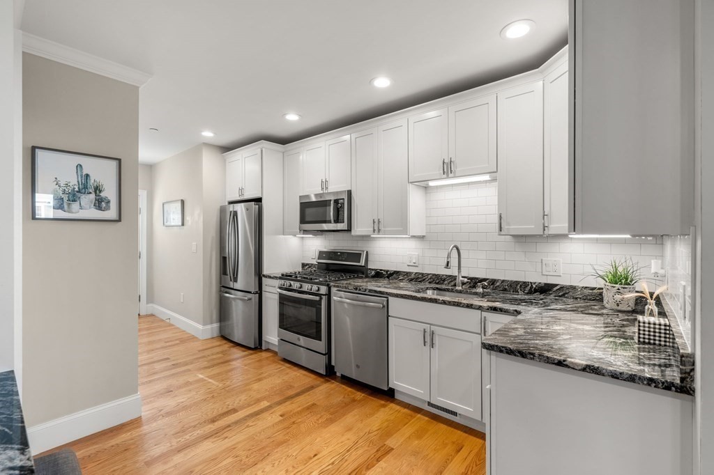 25 Cherry Street, Unit 3 Danvers, MA 01923 - Photo 6 of 27 a large kitchen with stainless steel appliances granite countertop a stove a sink and a refrigerator