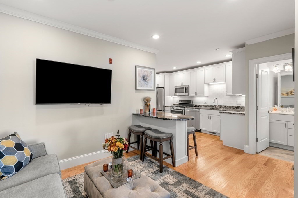 25 Cherry Street, Unit 3 Danvers, MA 01923 - Photo 8 of 27 a kitchen with stainless steel appliances kitchen island granite countertop a sink and cabinets