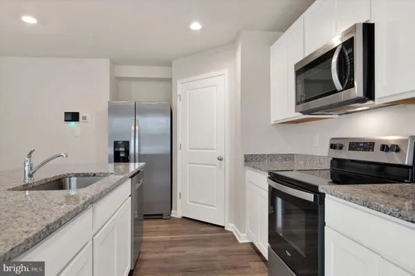 a kitchen with stainless steel appliances granite countertop a sink and a microwave