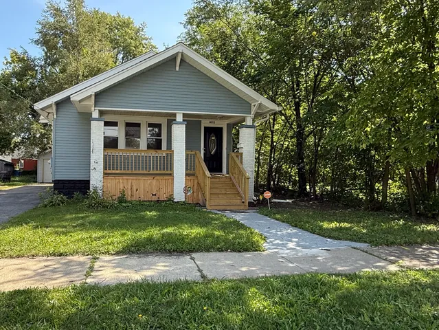 a front view of a house with a garden and yard