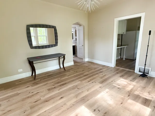 a view of a livingroom with wooden floor and a workspace