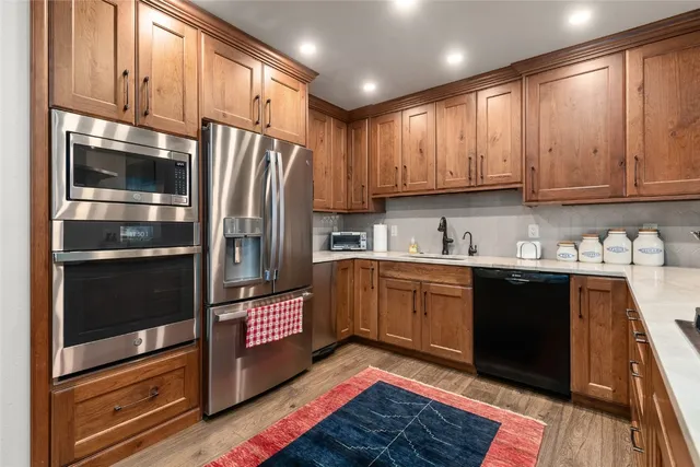 a kitchen with stainless steel appliances granite countertop a refrigerator and a stove top oven