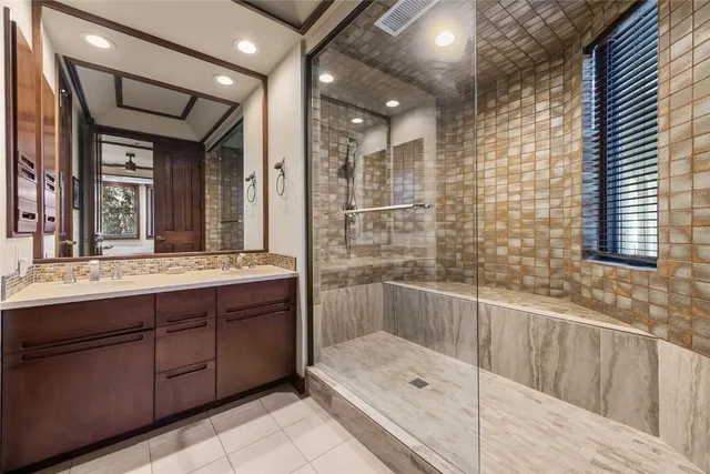 a bathroom with a tub sink shower and mirror