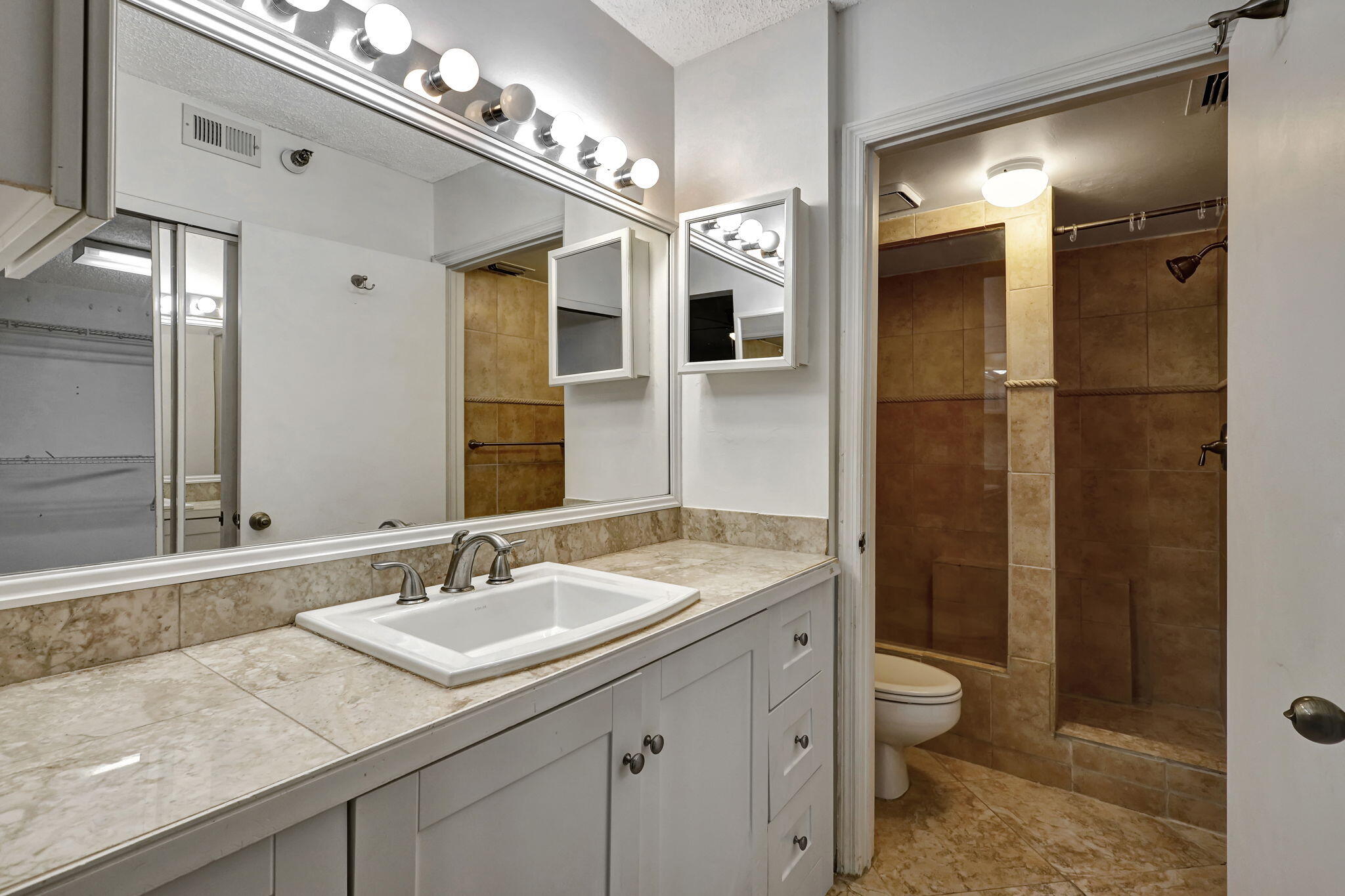320 Northwest 67th Street, Unit C207 Boca Raton, FL 33487 - Photo 18 of 39 a bathroom with a granite countertop sink a toilet and shower