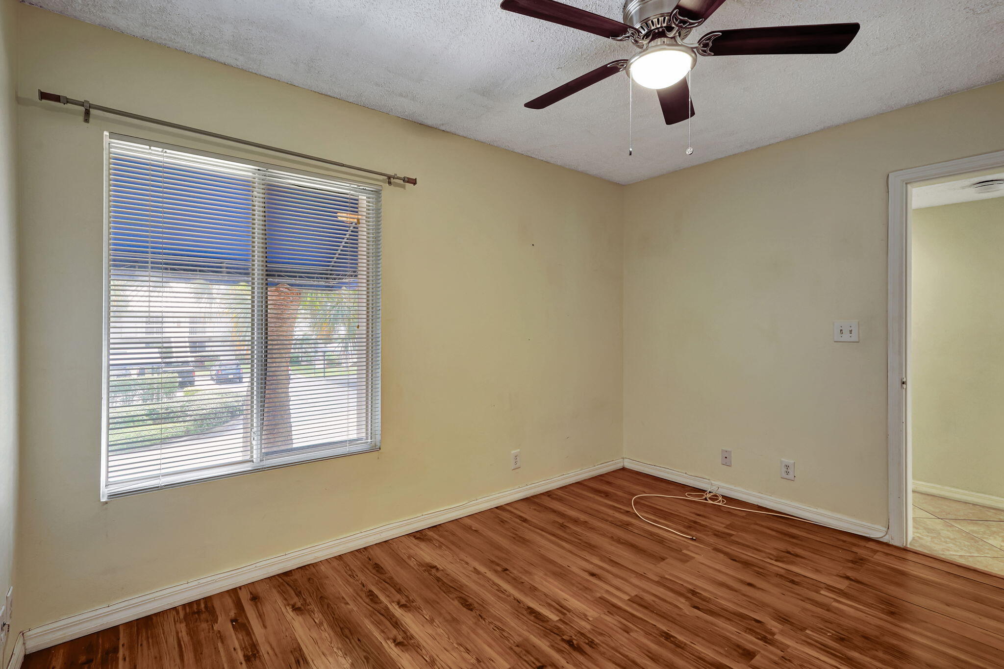 320 Northwest 67th Street, Unit C207 Boca Raton, FL 33487 - Photo 3 of 39 a view of empty room with wooden floor and fan