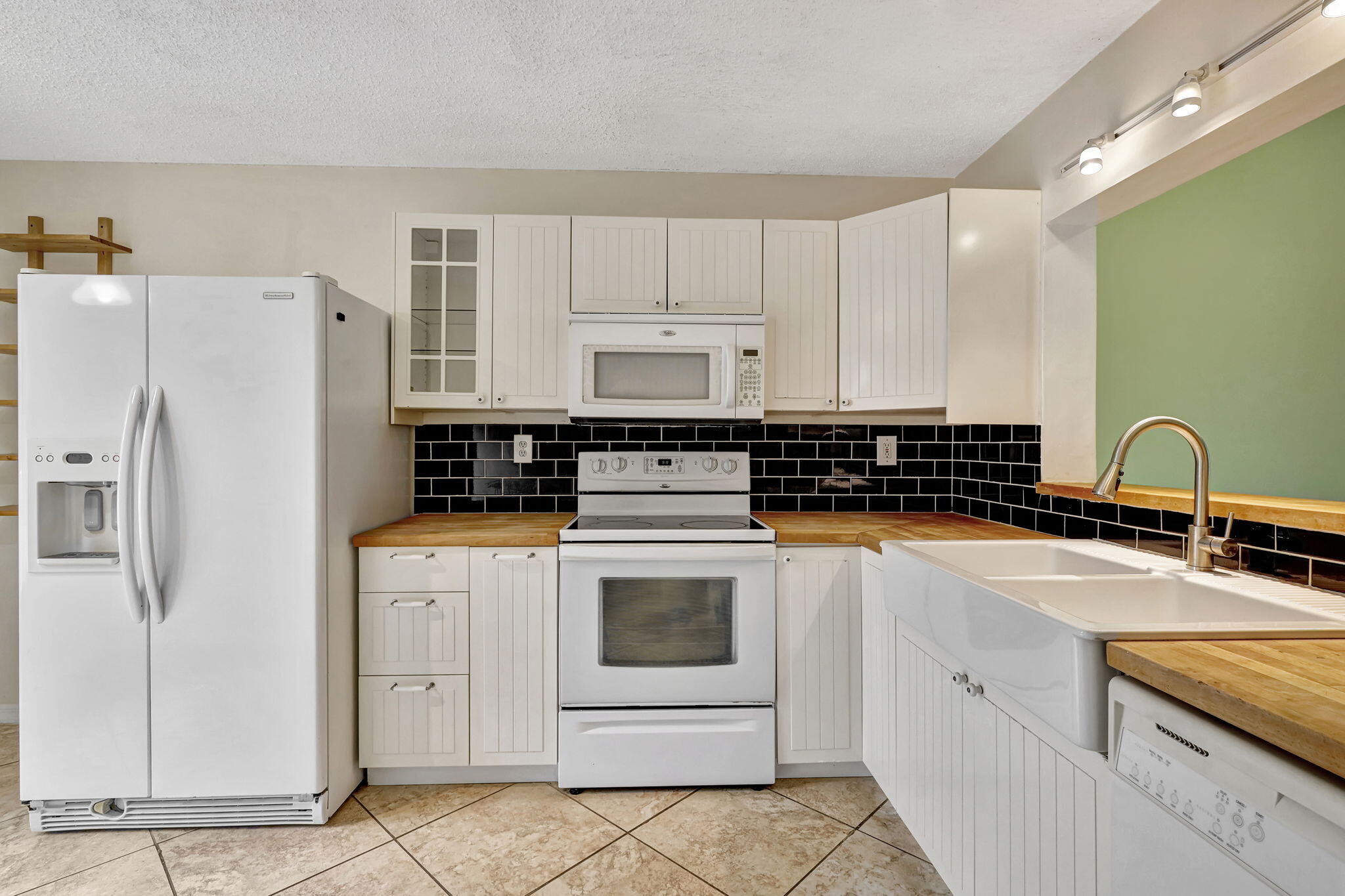 320 Northwest 67th Street, Unit C207 Boca Raton, FL 33487 - Photo 5 of 39 a white kitchen with stainless steel appliances granite countertop a stove a refrigerator and a sink