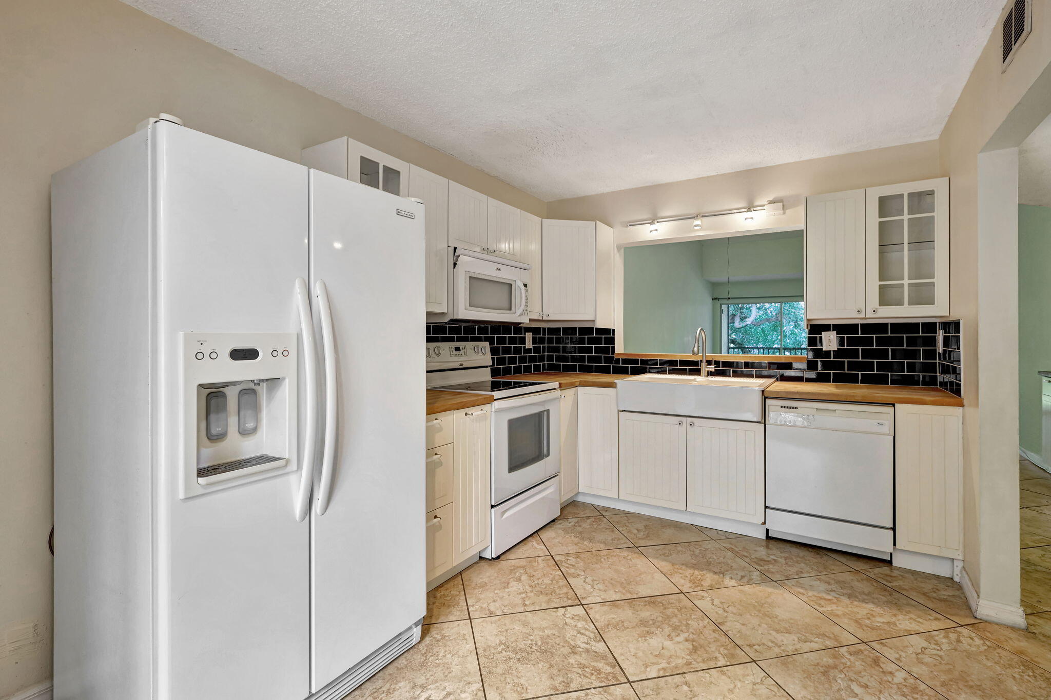 320 Northwest 67th Street, Unit C207 Boca Raton, FL 33487 - Photo 6 of 39 a kitchen with white cabinets and white appliances