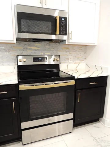 a stove top oven sitting inside of a kitchen