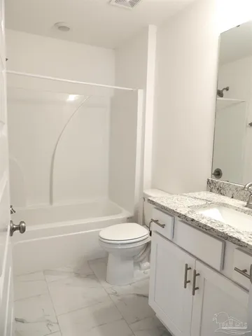 a bathroom with a granite countertop toilet a sink and a bathtub