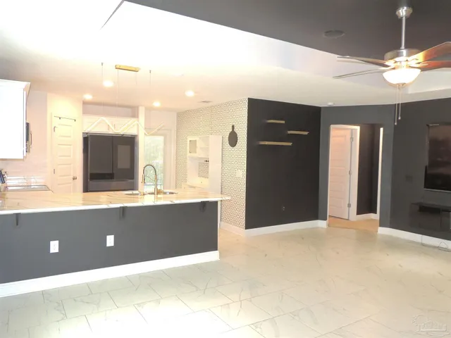 a view of kitchen with kitchen island a sink a refrigerator and a fireplace