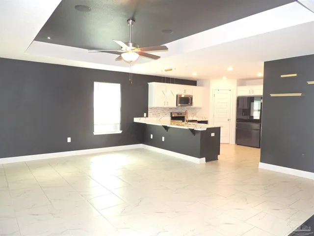a large kitchen with a window and stainless steel appliances