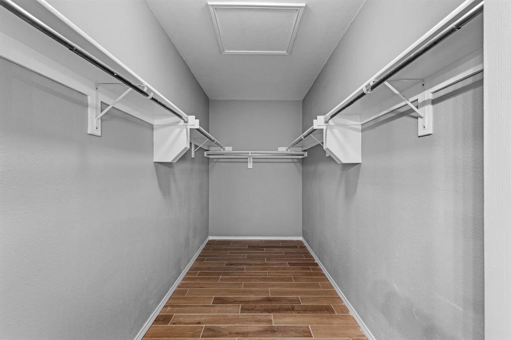 2700 Hereford Road Denton, TX 76210 - Photo 19 of 36 Interior closet featuring wood-finish flooring, light gray wall finish, white shelving, and dual hanging rods