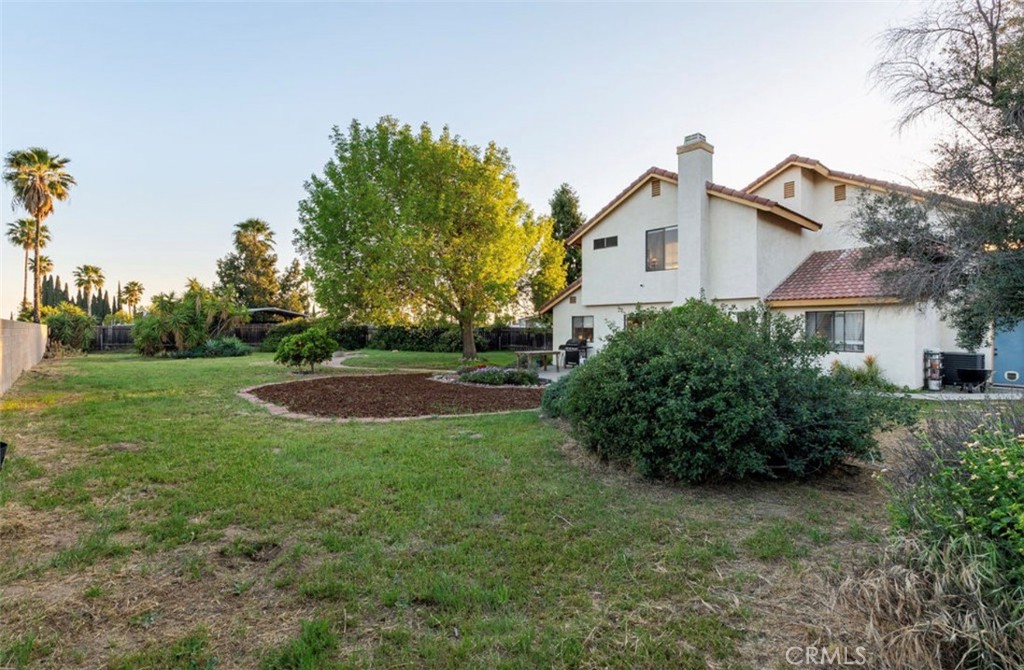 993 South Date Avenue Rialto, CA 92376 - Photo 10 of 27 a view of a white house next to a yard with plants and trees