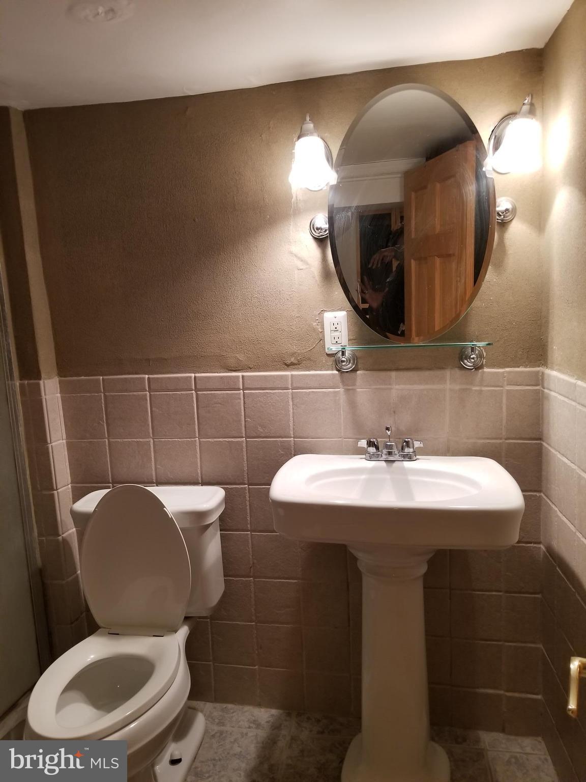 1237 Oates Street Northeast Washington, DC 20002 - Photo 13 of 15 a bathroom with a toilet a sink and mirror