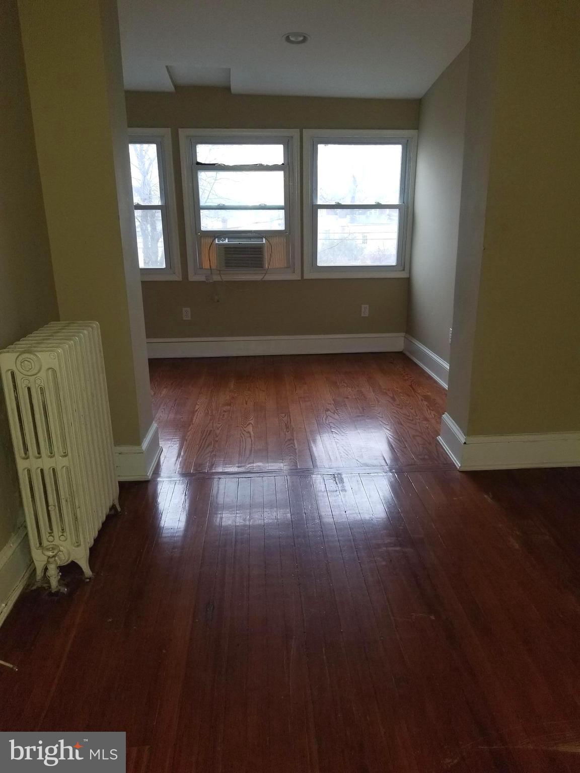 1237 Oates Street Northeast Washington, DC 20002 - Photo 9 of 15 an empty room with wooden floor and windows
