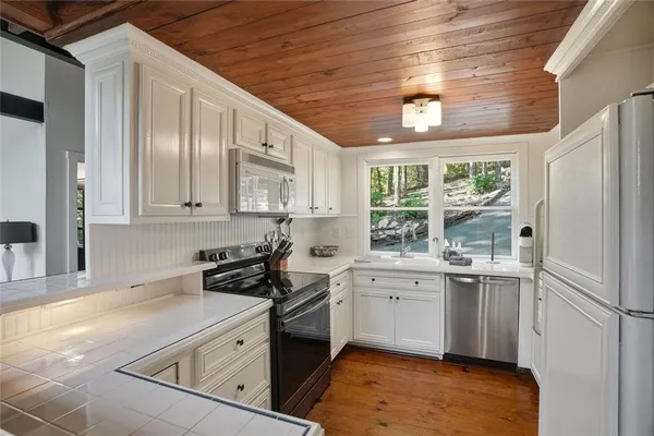 a kitchen with stainless steel appliances granite countertop a sink a stove and refrigerator